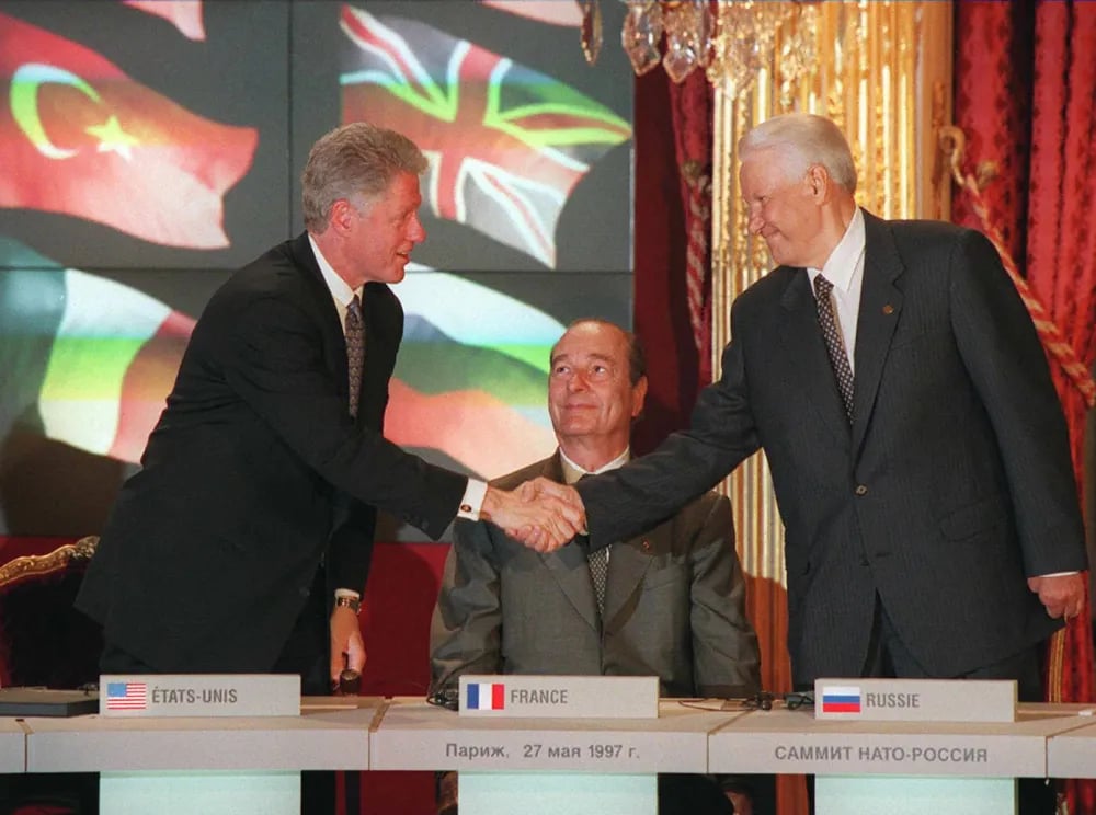 Bill Clinton shakes hands with his Boris Yeltsin as Jacques Chirac looks on, during the signing ceremony of the NATO-Russia Founding Act in Paris