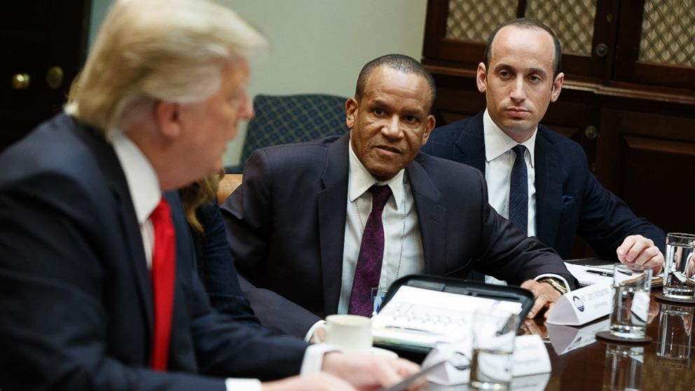 Stephen Miller, senior adviser to President Donald Trump, right, and Larry McKenney of Capitol Radiology listen as Trump speaks during a meeting with business leaders in the Roosevelt Room of the White House in Washington