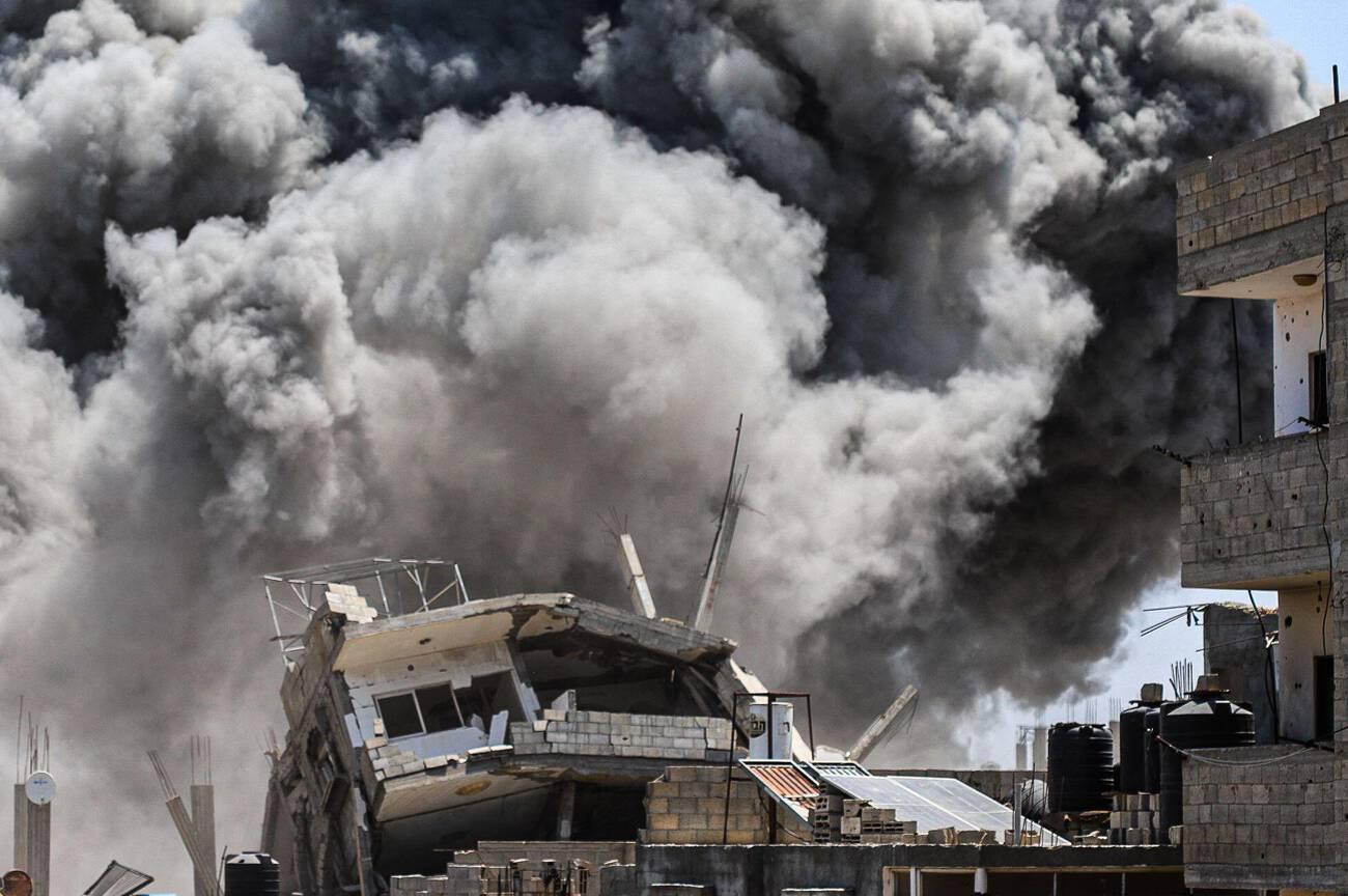 Smoke rises from residential buildings in Gaza City after an Israeli airstrike, amid reports of famine and genocide in Gaza.
