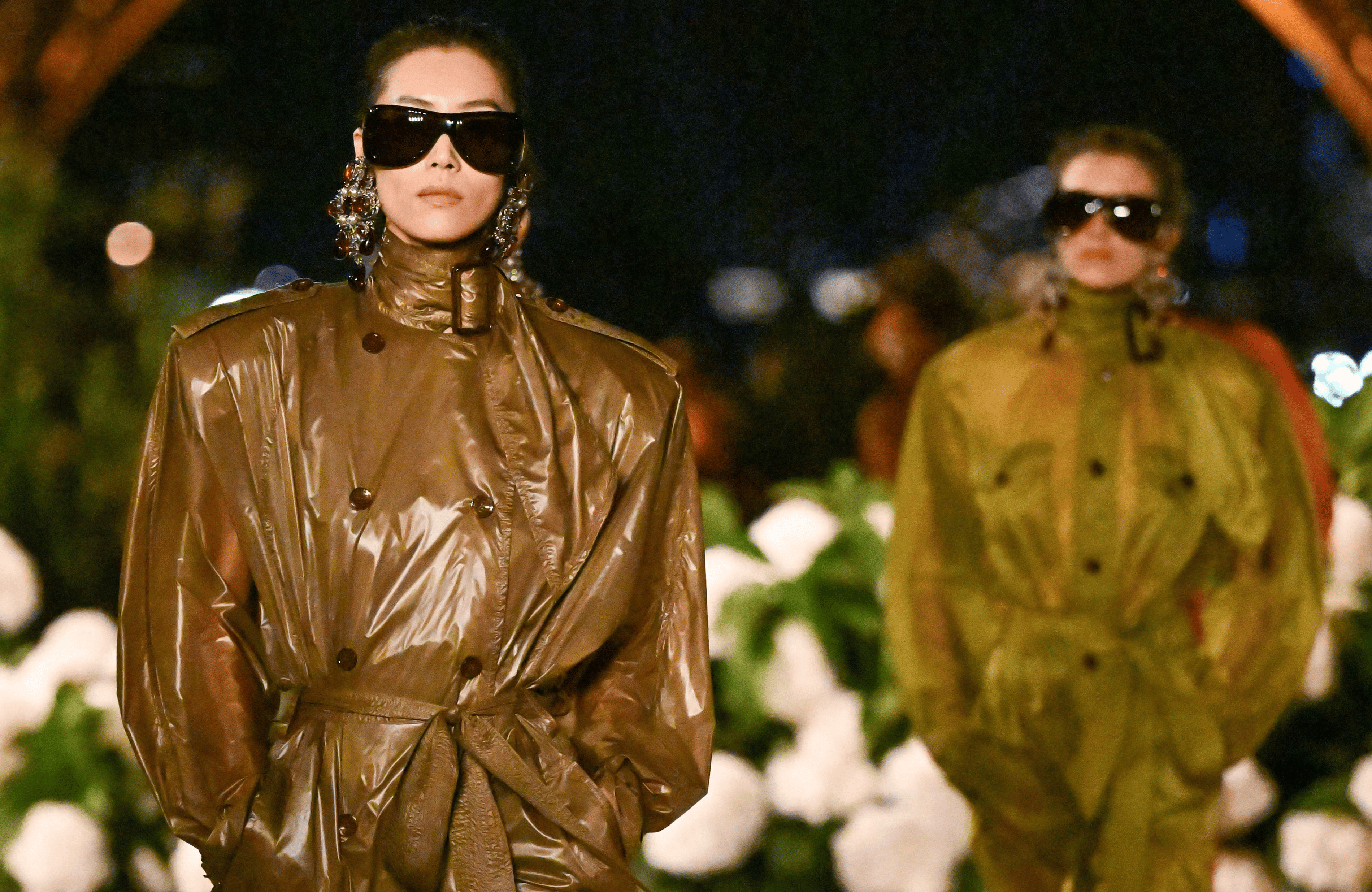 Saint Laurent Spring 2026 at Trocadéro with Eiffel Tower backdrop; model in nylon trench-dress on reflective runway