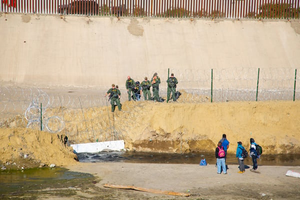 Four people standing near a mountain viewpoint, illustrating urban migration.