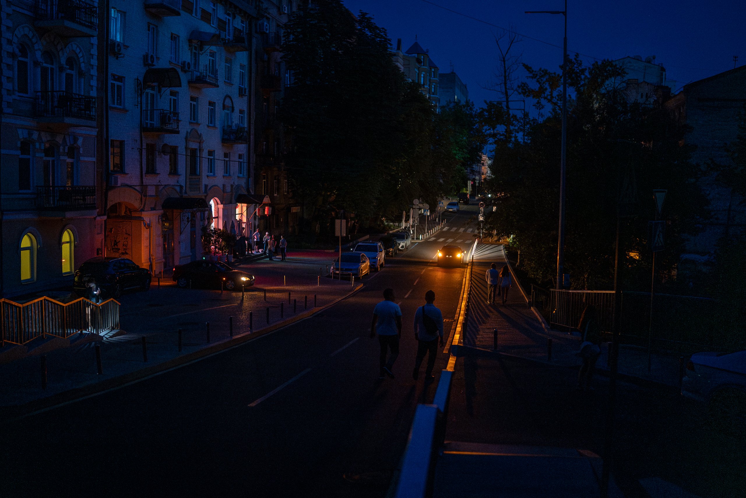 Kyiv residents charge phones in a café running a small generator during a rolling blackout