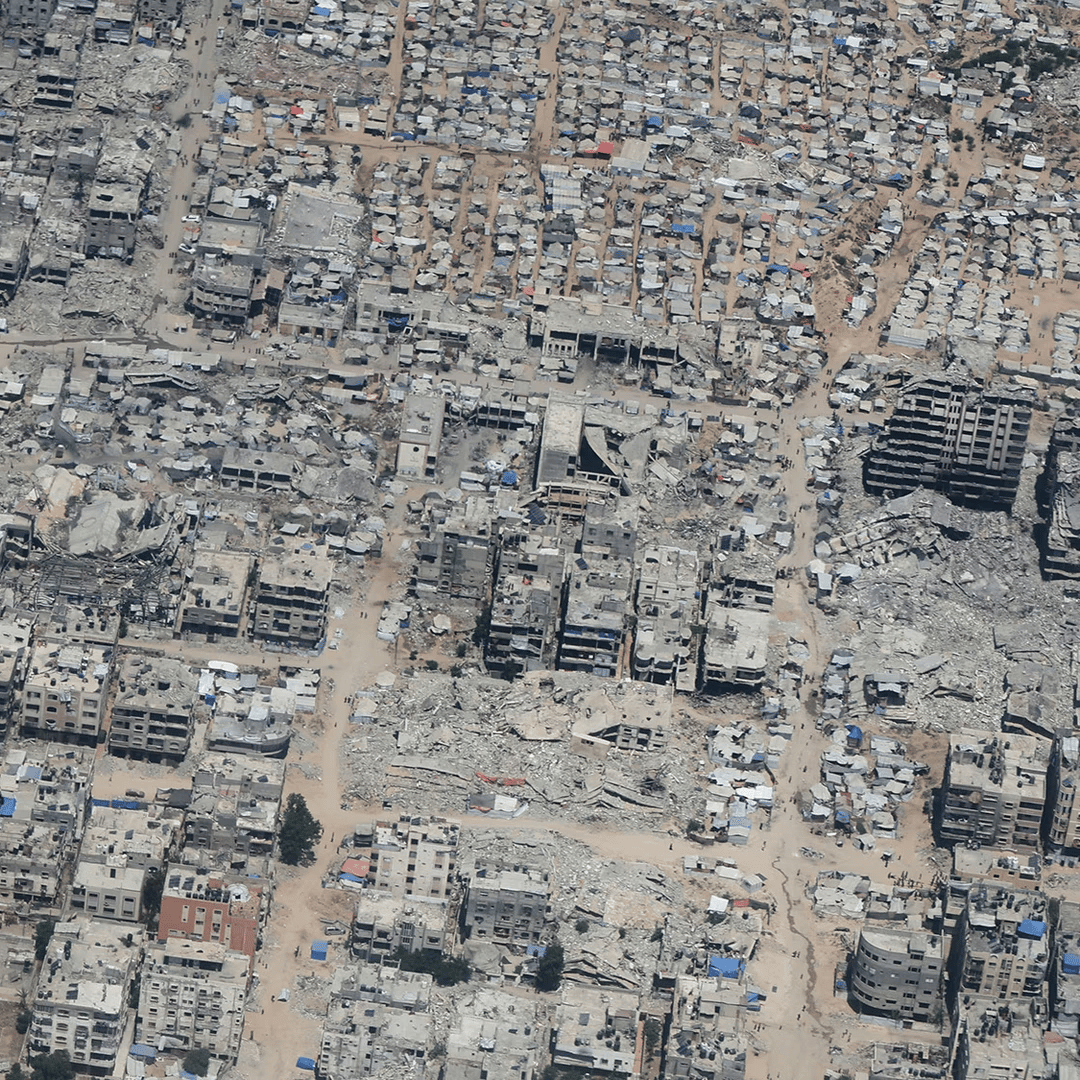 Aerial view of Gaza showing destruction and civilians awaiting aid during Israel-Palestine conflict day 721