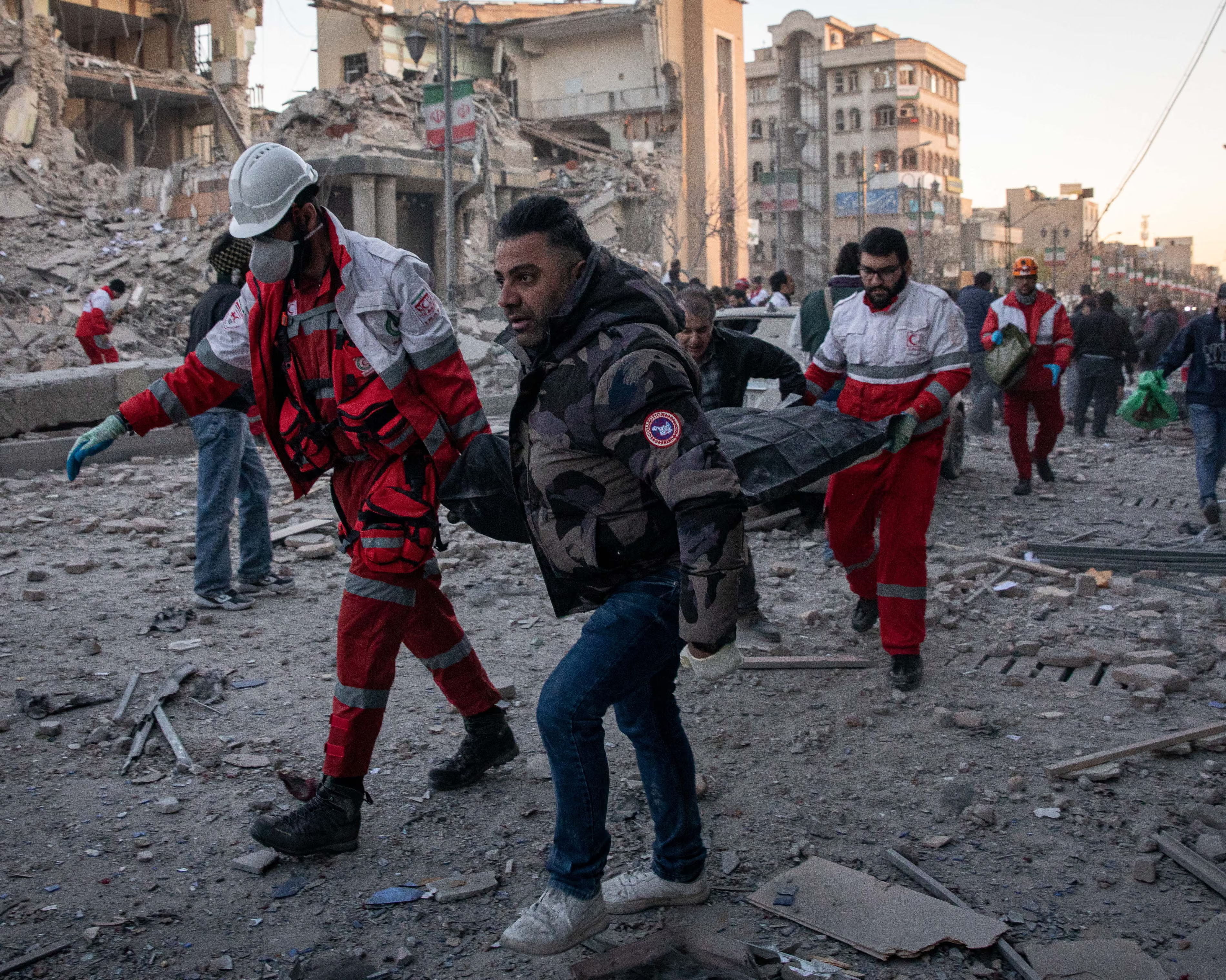 Rescue workers carry injured civilians after US and Israeli airstrikes in Tehran during the Iran war.