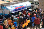 Civilians gather near aid trucks in Gaza amid humanitarian crisis and ongoing conflict