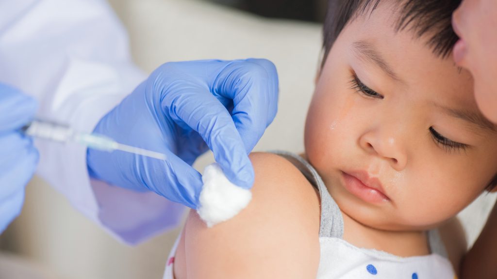 Pediatrician preparing MMR vaccine for infant immunization