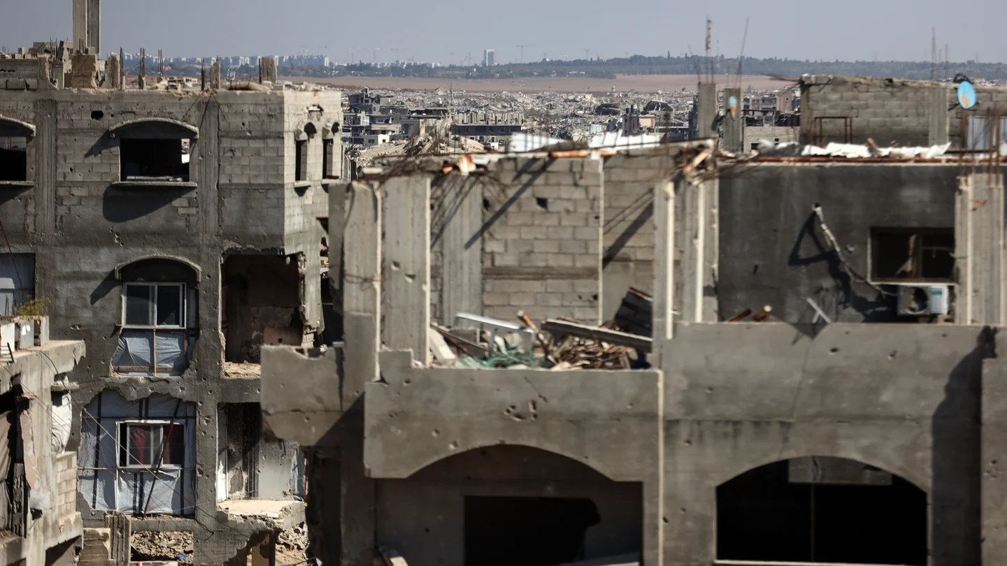 Palestinians inspect destruction after an Israeli airstrike in Gaza City that killed the son of Hamas negotiator Khalil al-Hayya
