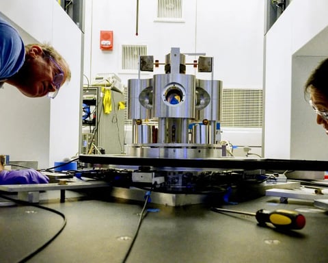 NIST physicist Stephan Schlamminger examines the torsion balance used to measure the gravitational constant Big G