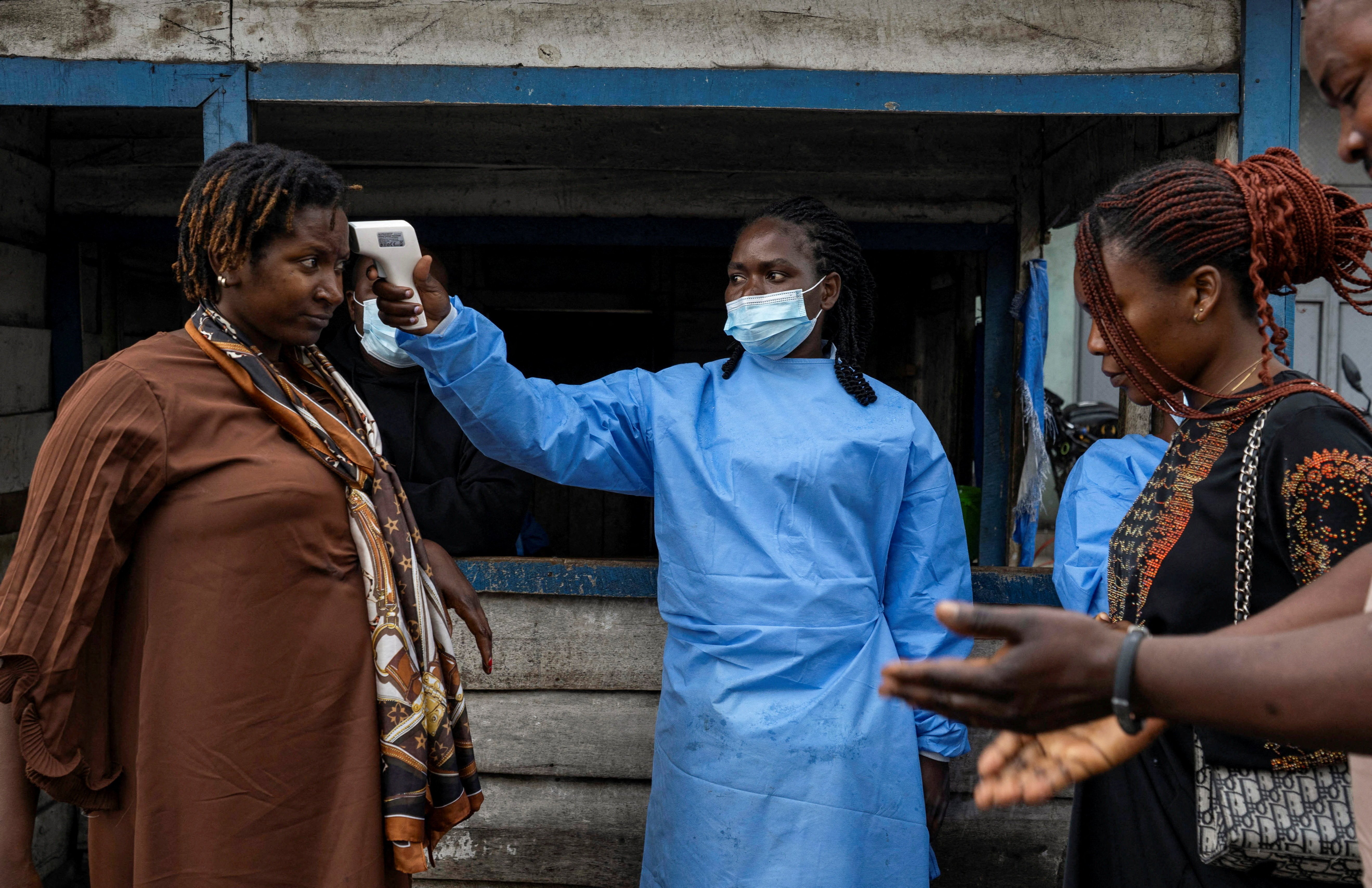 A health worker takes the temperature of a woman at the Kanyaruchinya checkpoint near Goma during the 2026 Ebola outbreak